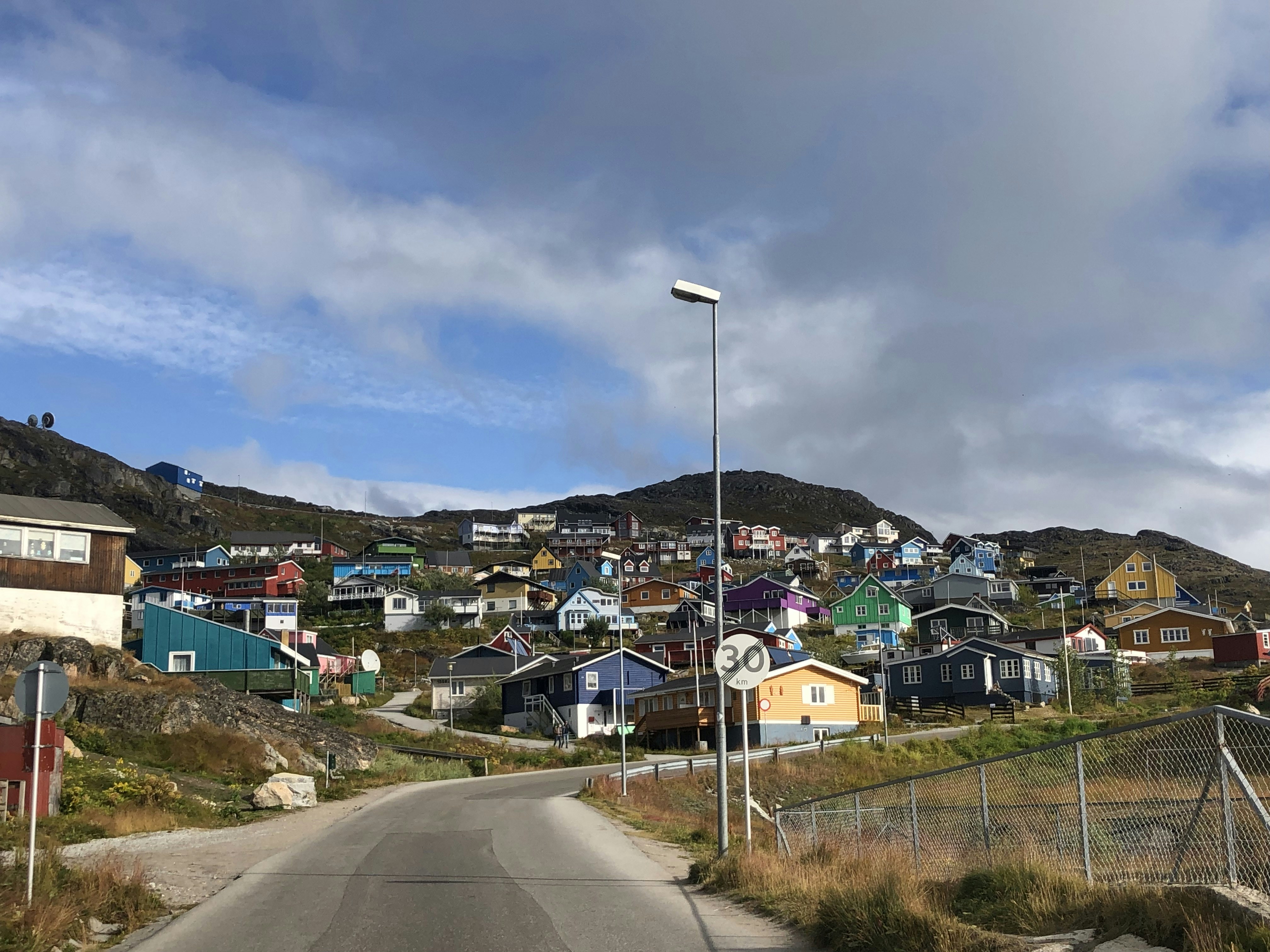 houses near road under blue sky during daytime