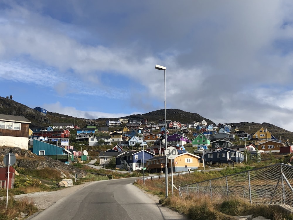 houses near road under blue sky during daytime