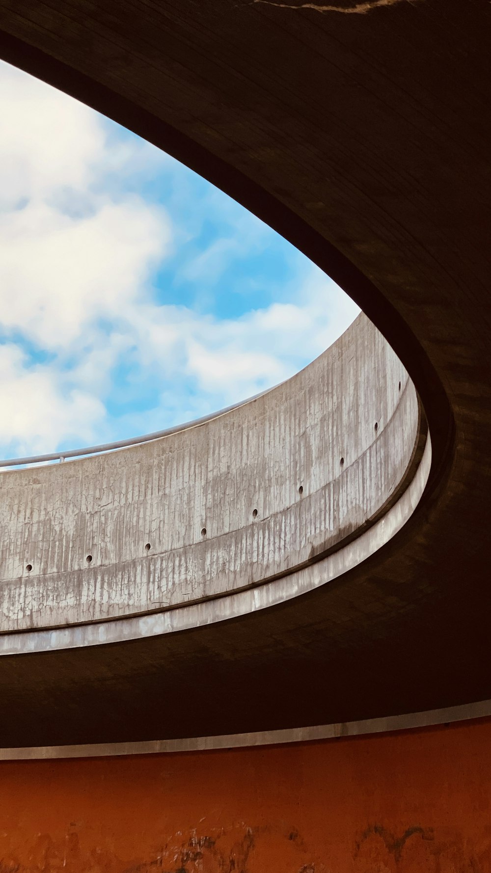 brown concrete wall under blue sky and white clouds during daytime