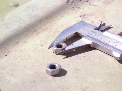 Close-up of a precision-engineered metal component being measured with calipers.