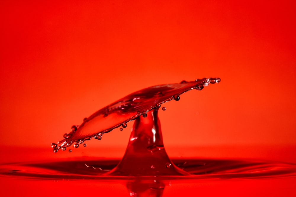 Gota de agua sobre superficie roja