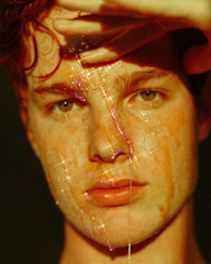 Close-up of a radiant face illuminated by soft spa lighting with laser equipment in the background.