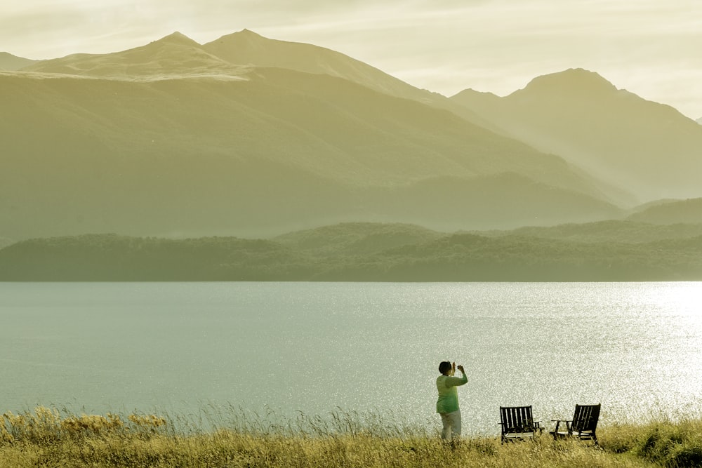 person in green shirt standing on brown wooden dock during daytime