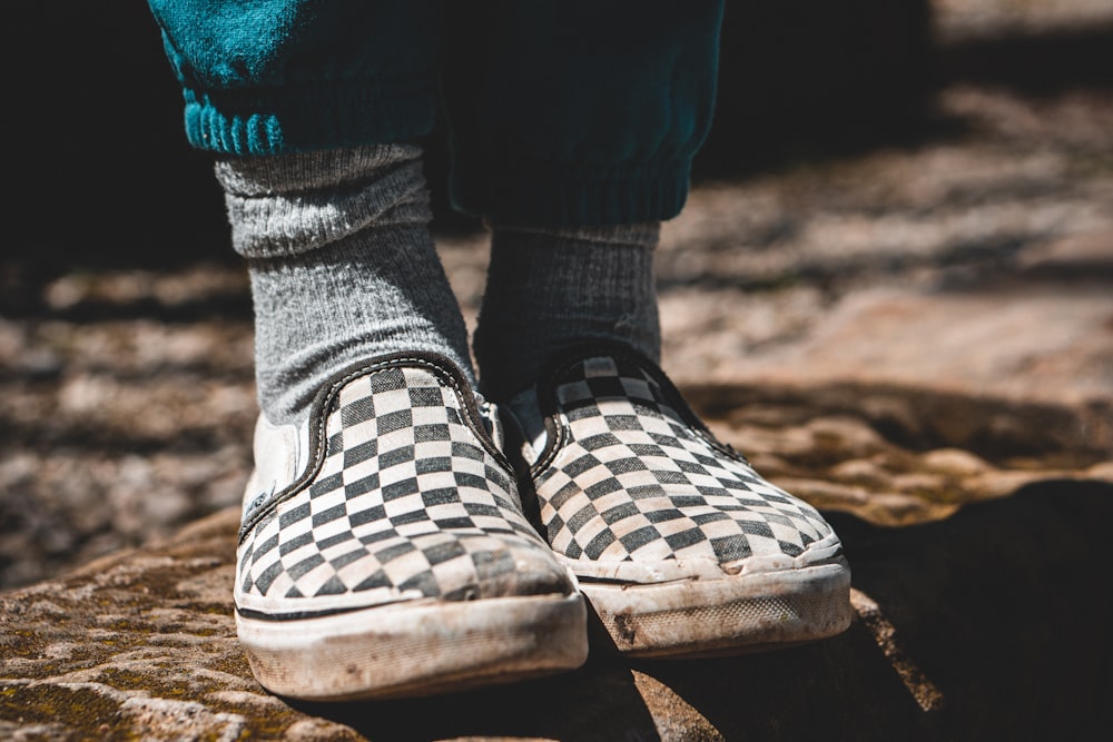 person wearing white and black checkered slip on shoes