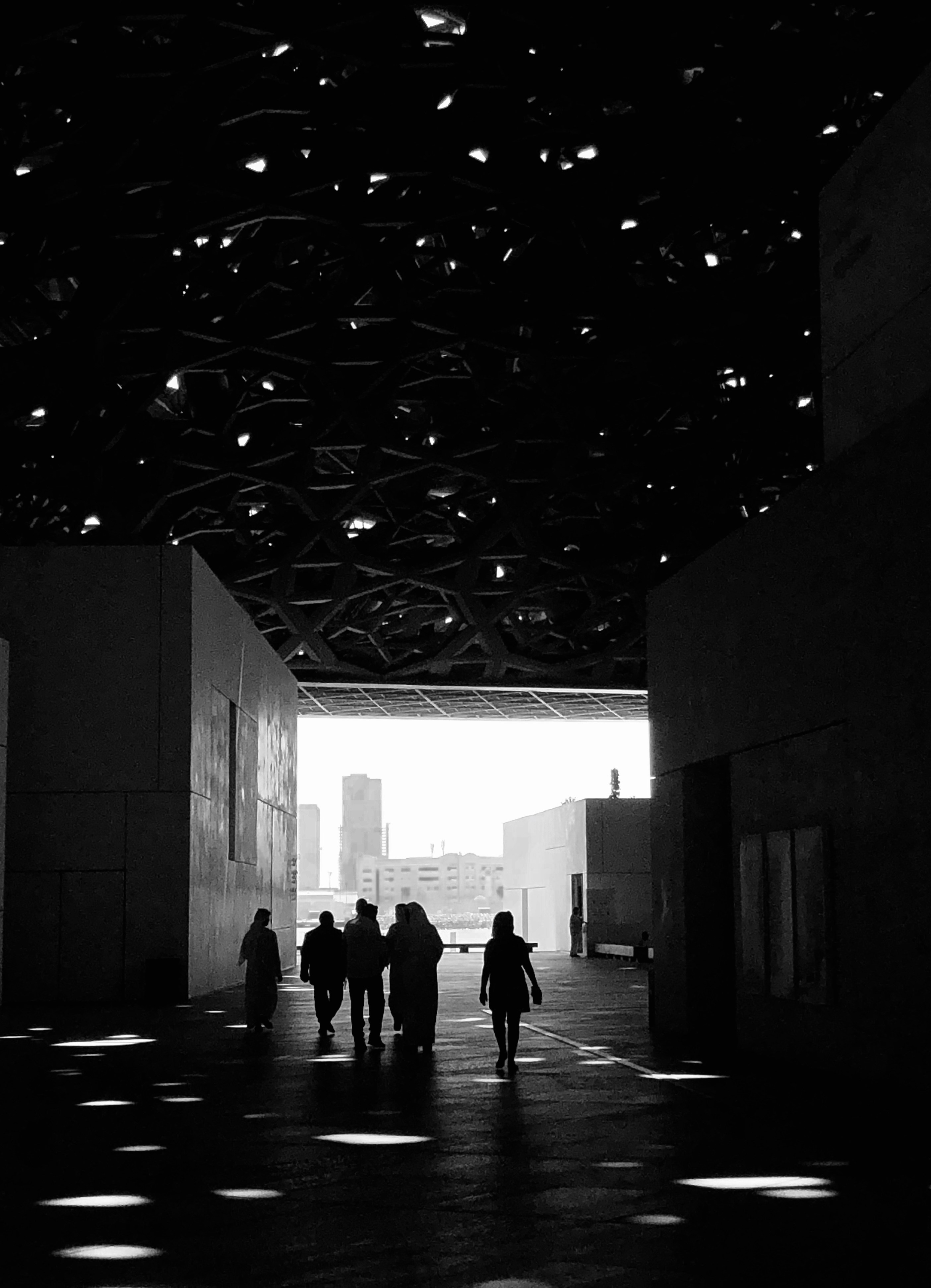 silhouette de personnes marchant sur le trottoir pendant la journée