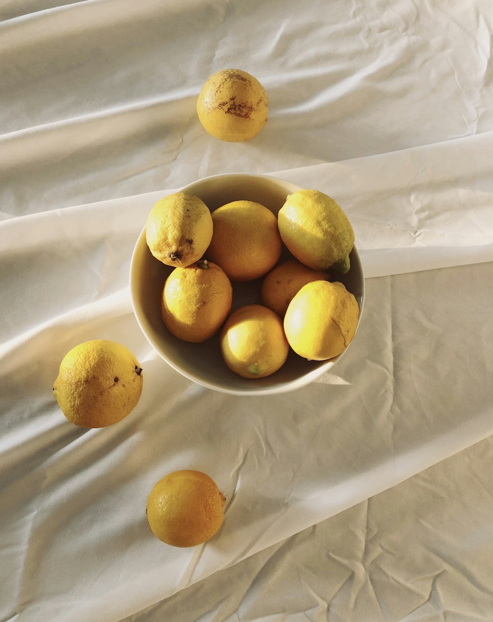 yellow citrus fruits on white textile