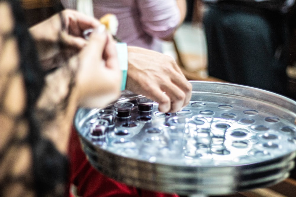 person holding clear glass round tray