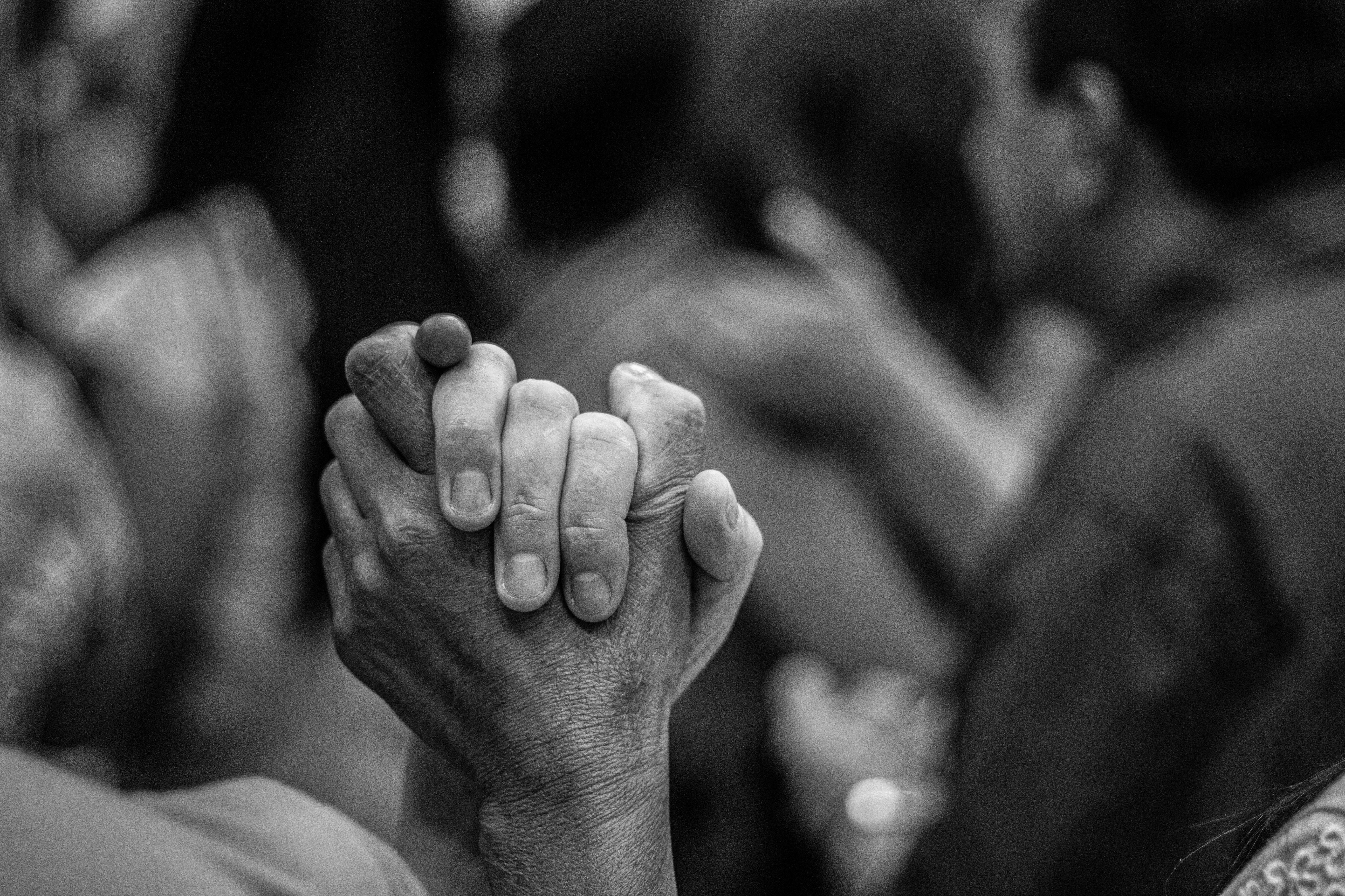 grayscale photo of people holding hands