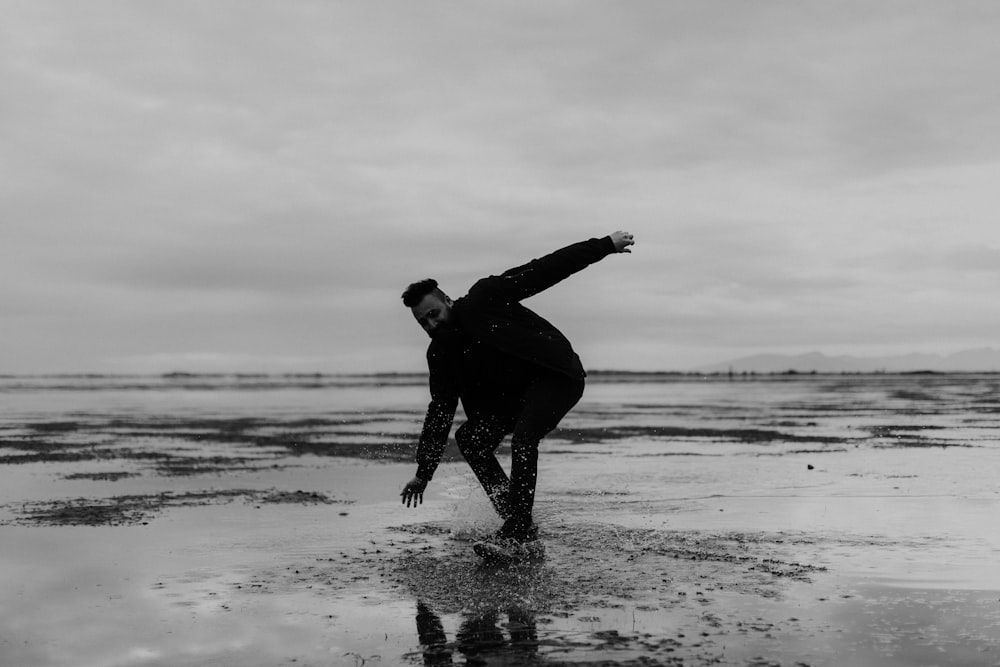 man in black wet suit walking on beach