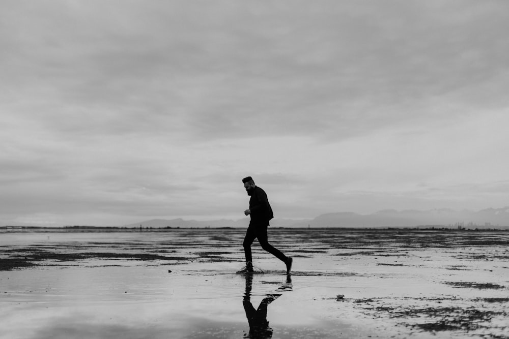 silhouette of man walking on beach during daytime