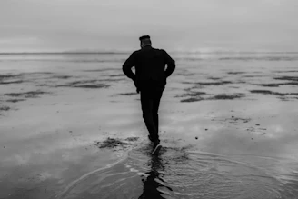 man in black jacket standing on water