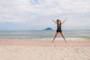Mujer saltando feliz en la playa durante el día.