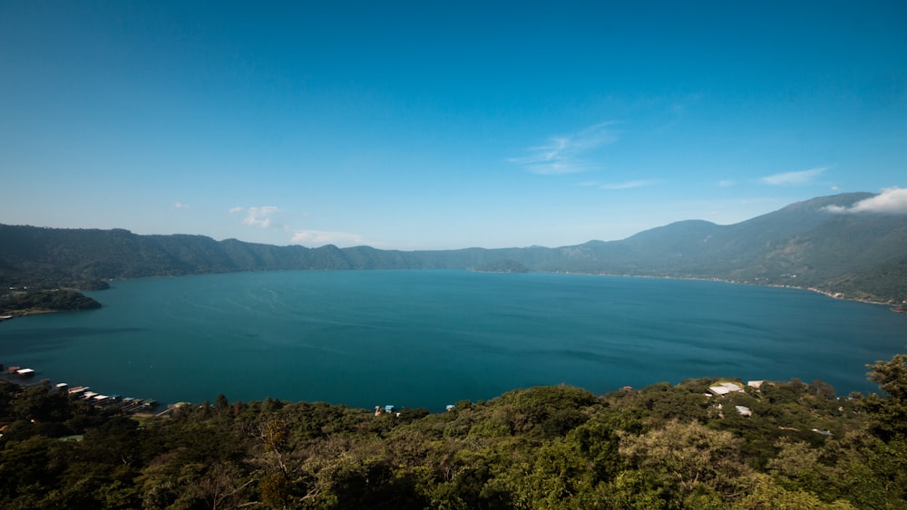 green mountain beside blue sea under blue sky during daytime