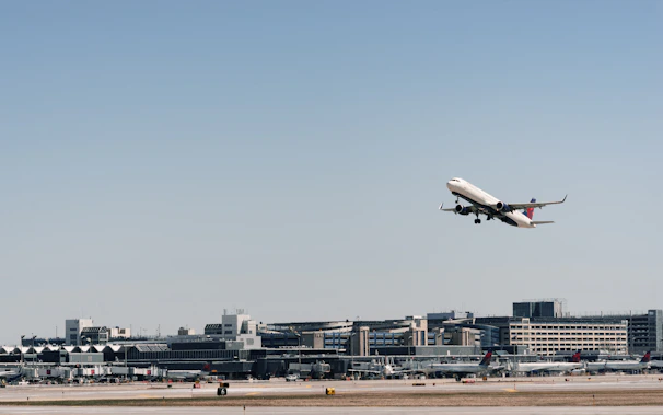 A cargo plane taking off from Dubai airport under a clear blue sky.