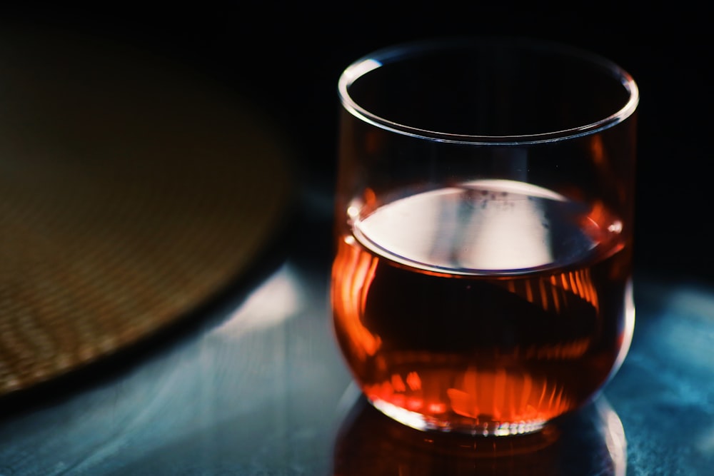 clear drinking glass with brown liquid