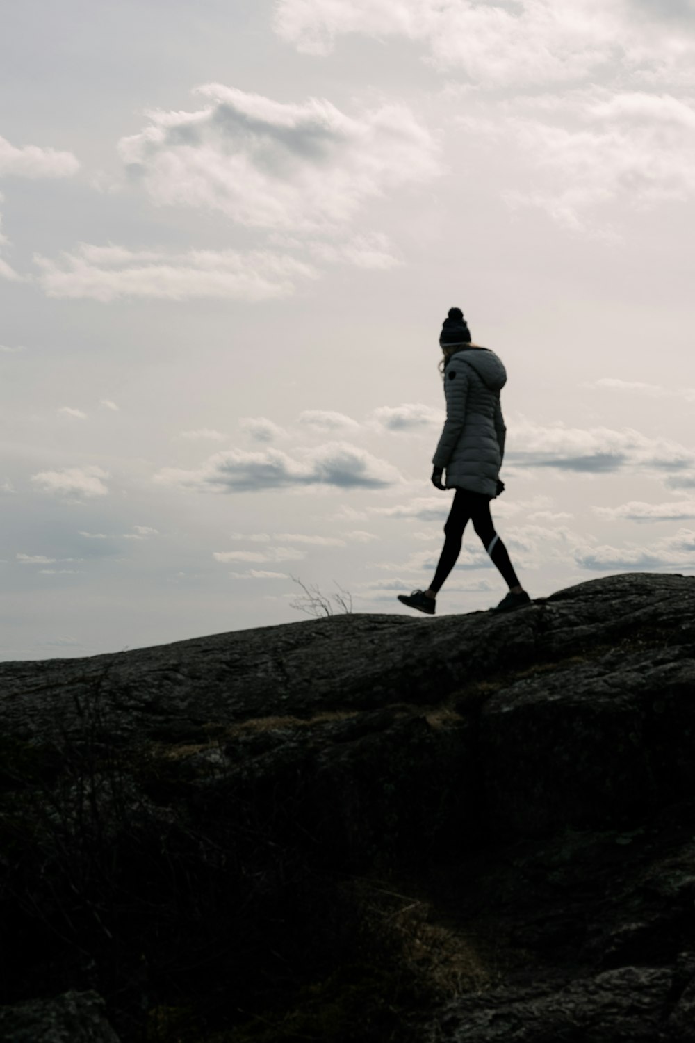 man in gray jacket standing on rock formation during daytime