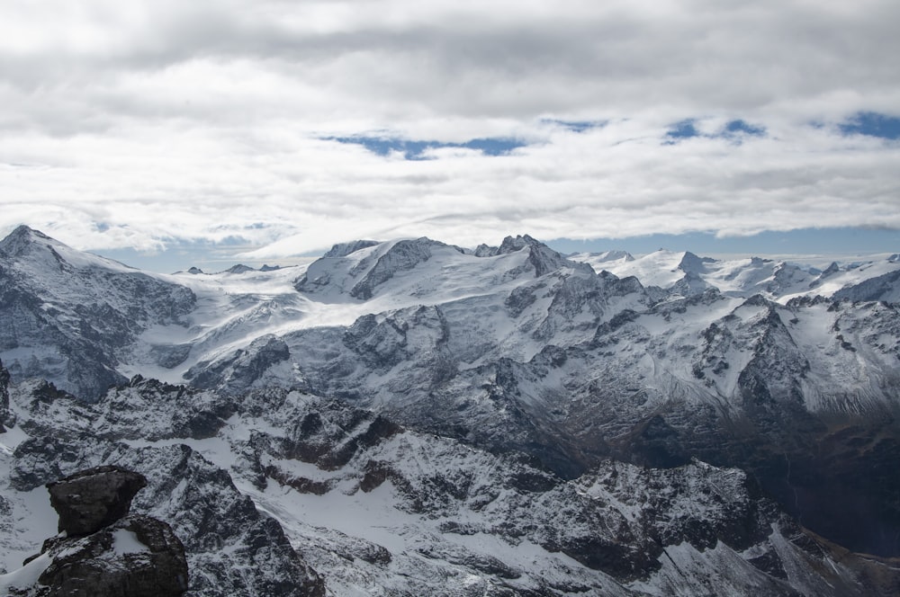 montanha coberta de neve sob céu nublado durante o dia