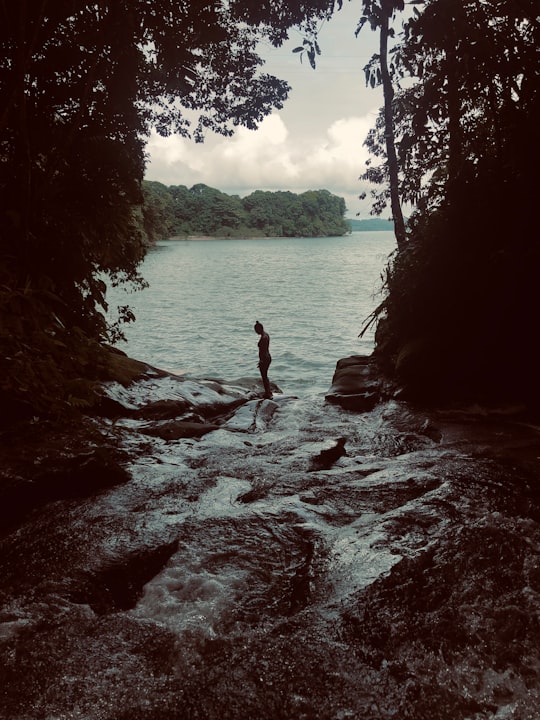 woman in black bikini standing on rock in the middle of body of water during daytime in Océano Pacífico Norte Colombia