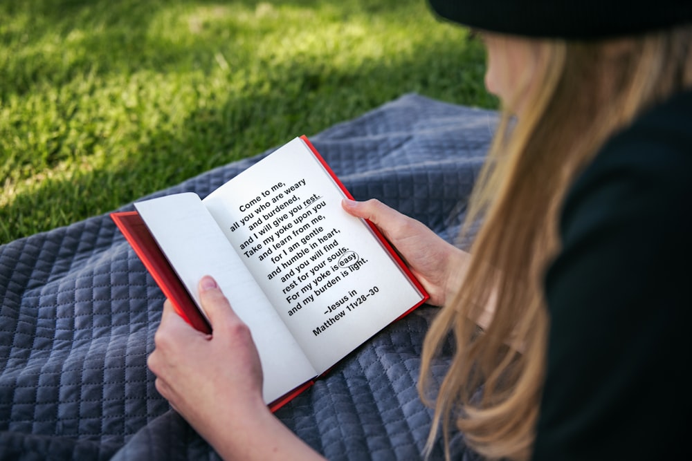 Mujer con camisa gris de manga larga leyendo libro