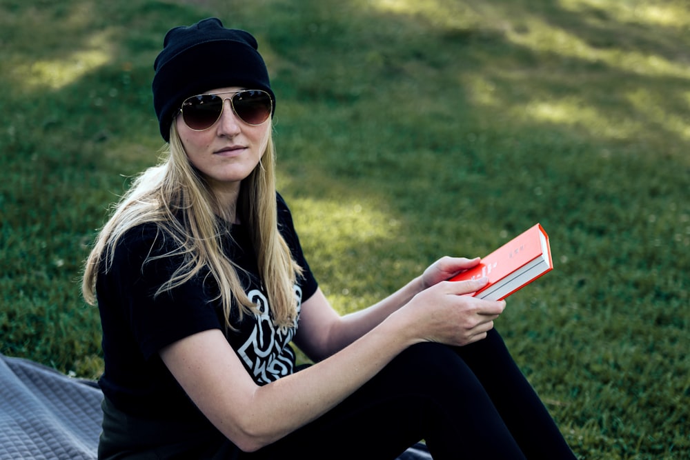 a woman sitting on the ground reading a book