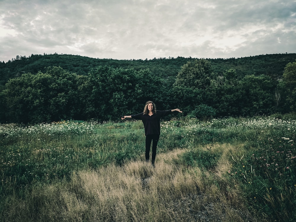 woman in black long sleeve shirt standing on green grass field during daytime