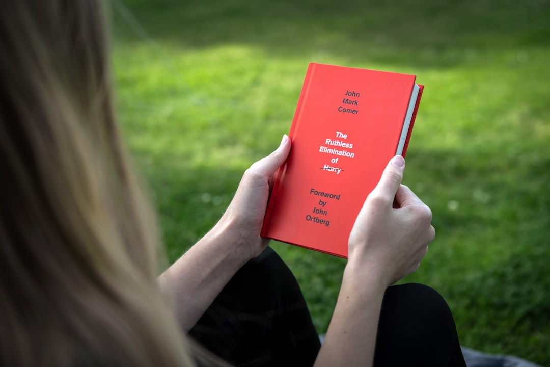 person holding red book during daytime