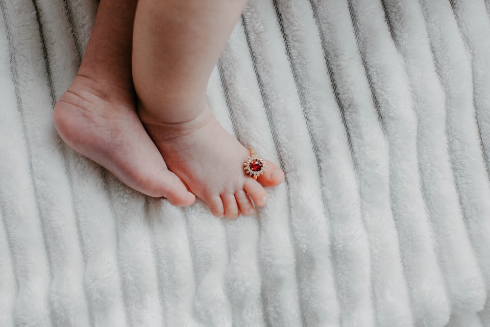 a baby's foot with a tiny red flower on it