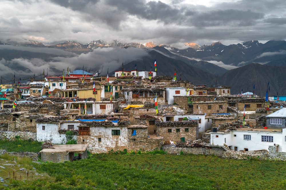 white and brown concrete houses near mountain under white clouds during daytime