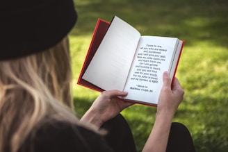 woman holding white and red book