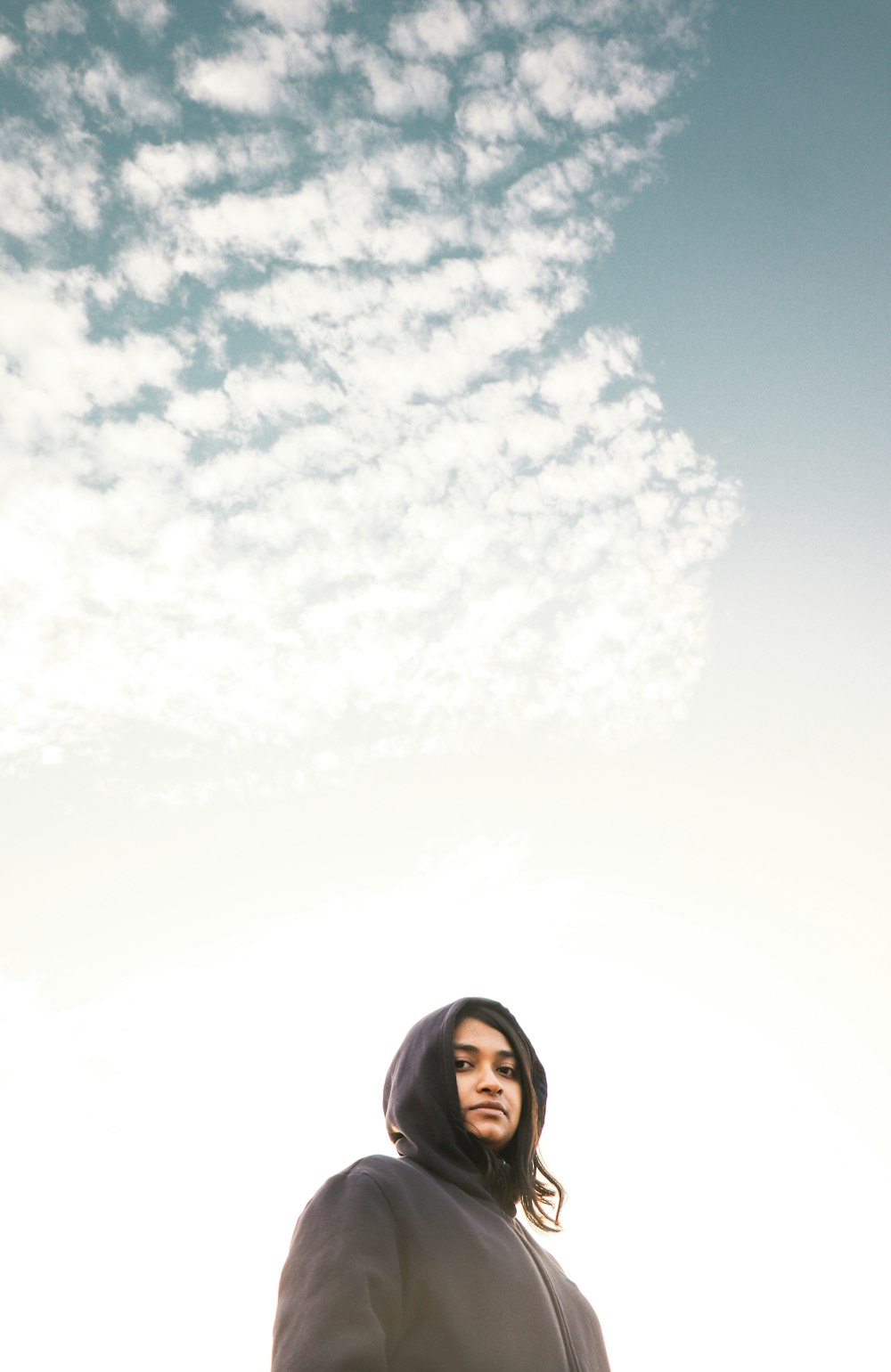 woman in black hoodie under white clouds