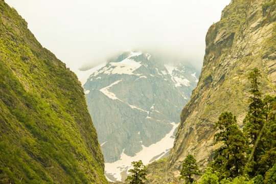 green and white mountains under white sky during daytime in Hemkund India