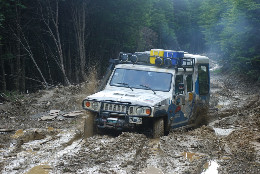 blue and white suv on dirt road during daytime