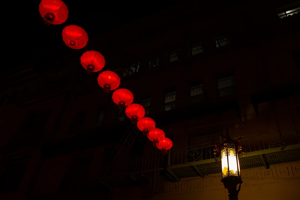 a row of red lanterns hanging from the side of a building