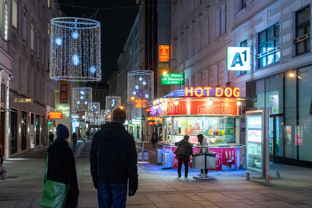 man in black jacket walking on sidewalk during nighttime