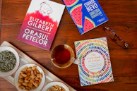 A delicate arrangement of herbal teas and wellness books on a wooden table.