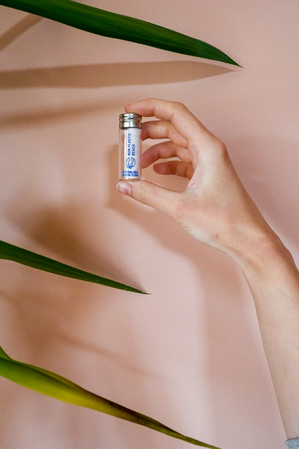 person holding white and blue labeled bottle