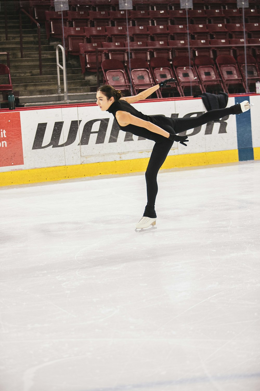 woman in black tank top and black pants playing ice hockey