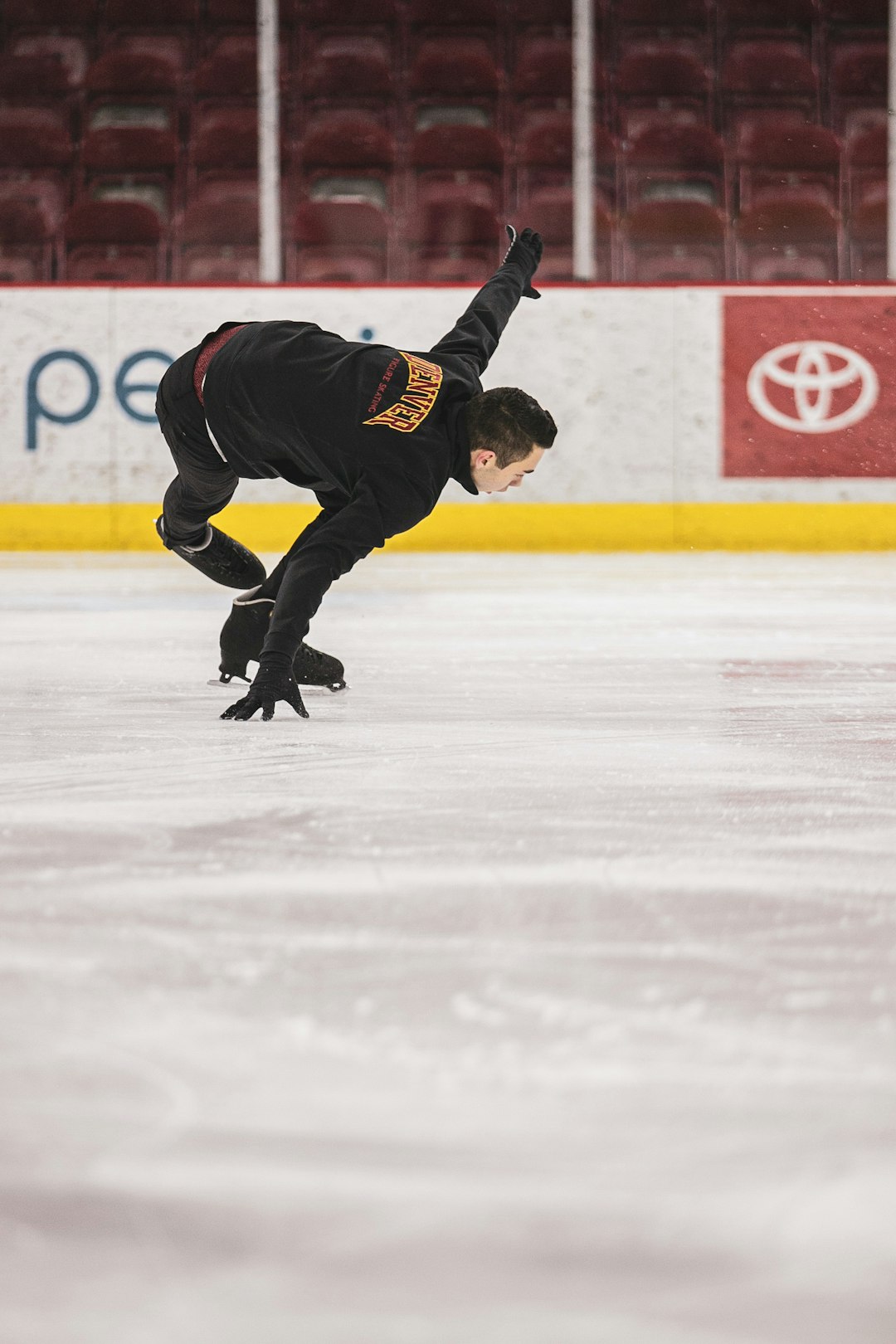 man in black jacket and black pants playing ice hockey