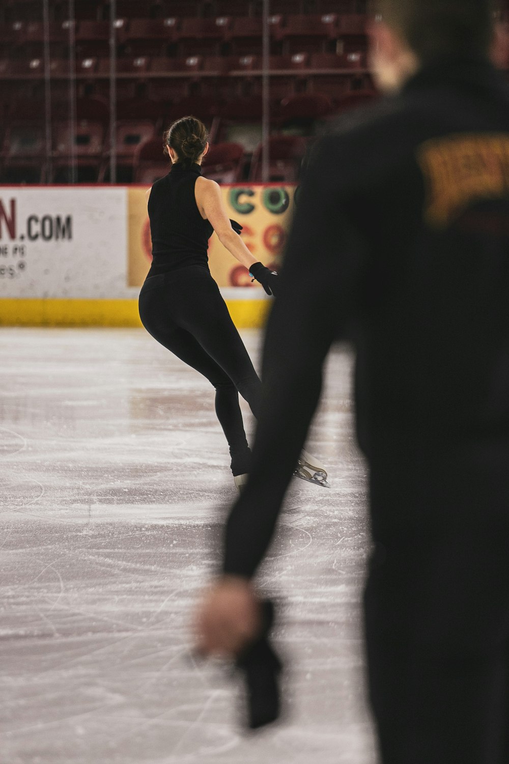 woman in black tank top and black leggings doing ice skating