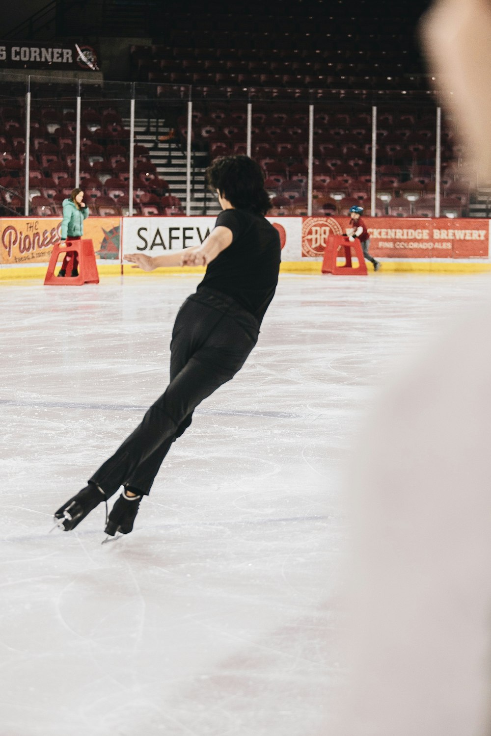 man in black pants and red shirt playing ice hockey