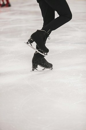 A hockey player in a black jacket skating on indoor ice, the kind of rink time Las Vegas youth and girls' hockey players are chasing across the valley