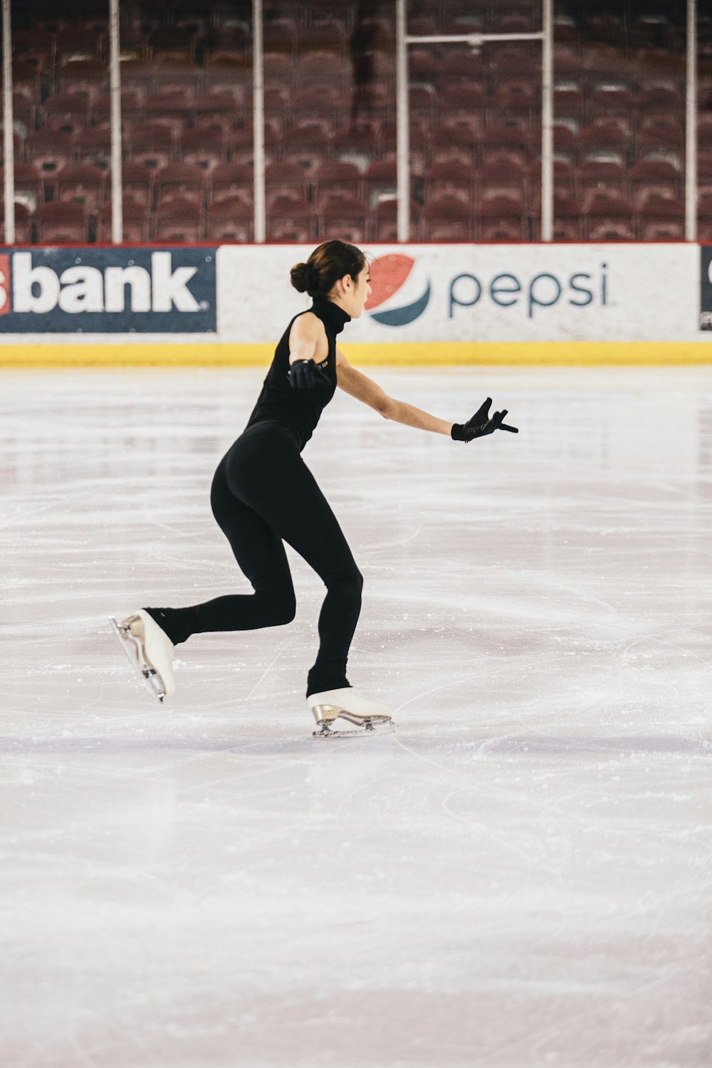 woman in black tank top and black pants doing ice skating
