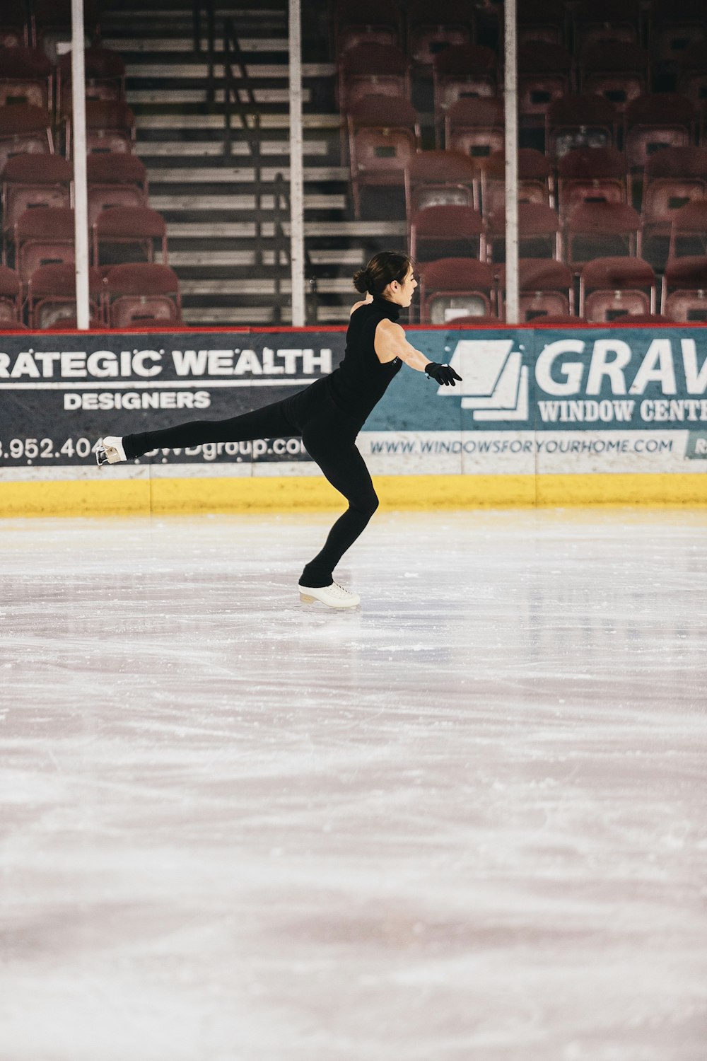 Hombre con camisa negra y pantalones jugando al hockey sobre hielo