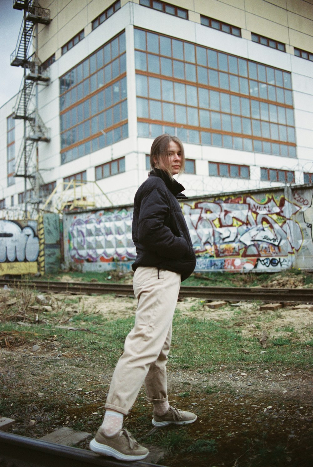 man in black jacket and brown pants standing on green grass field during daytime