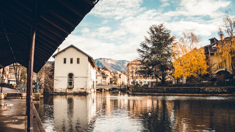 white and brown house near body of water during daytime