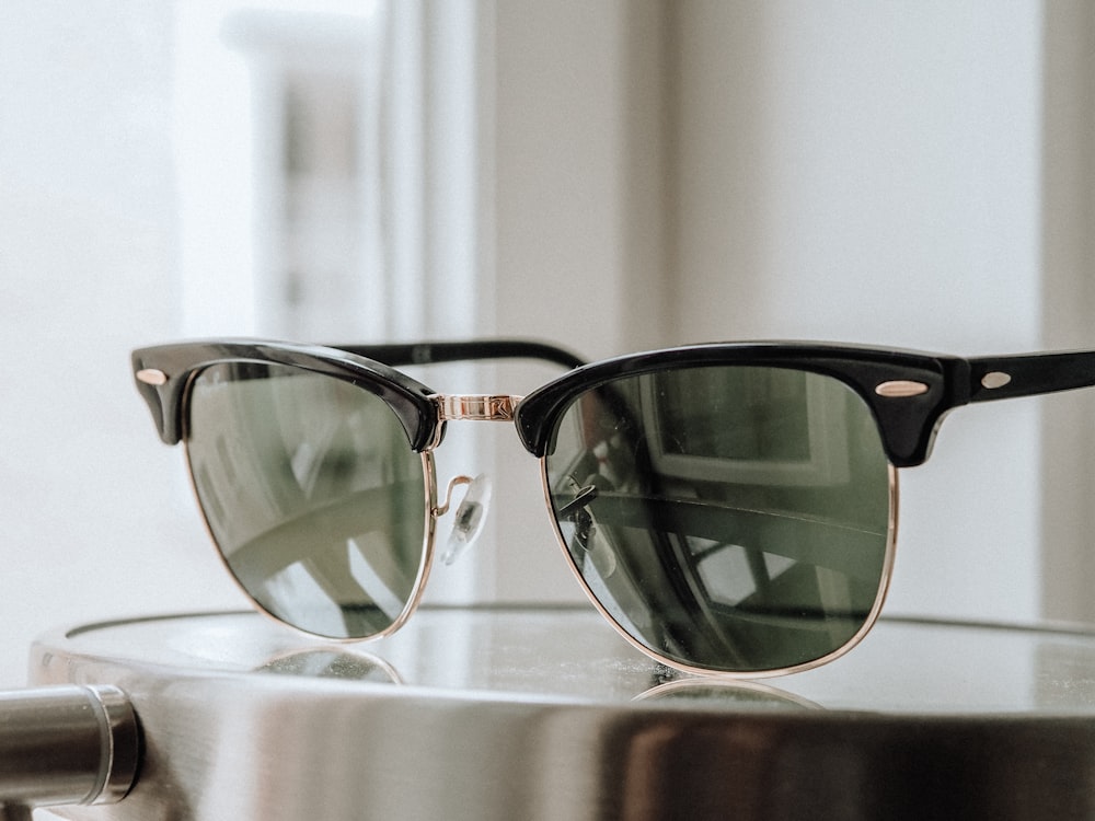 occhiali da sole con montatura nera su tavolo in legno marrone