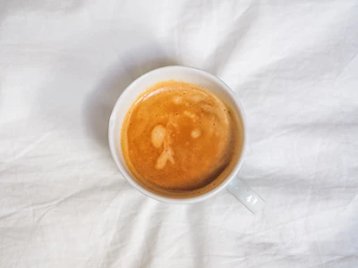 white ceramic mug with brown liquid