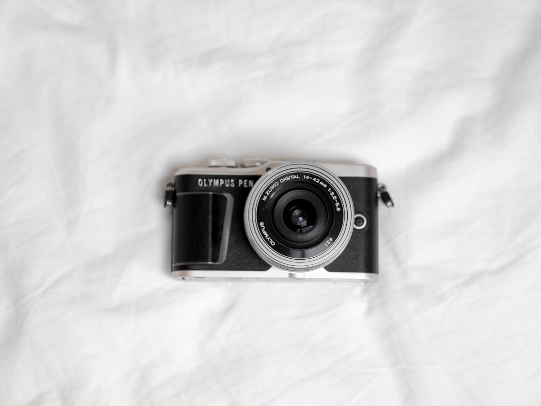 black and silver camera on white textile