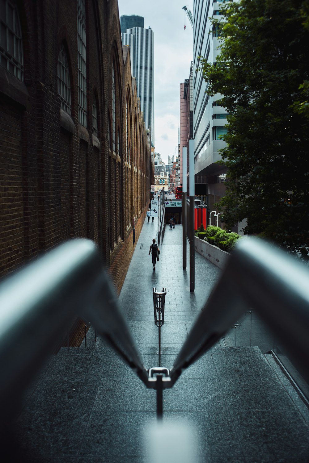 a man walking down a street next to tall buildings