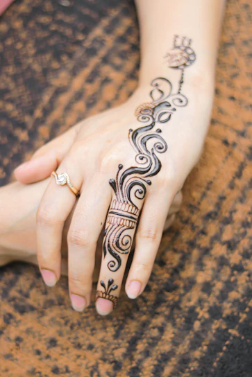 Close-up of intricate bridal mehendi design on a bride's hands with delicate floral and Arabic patterns.